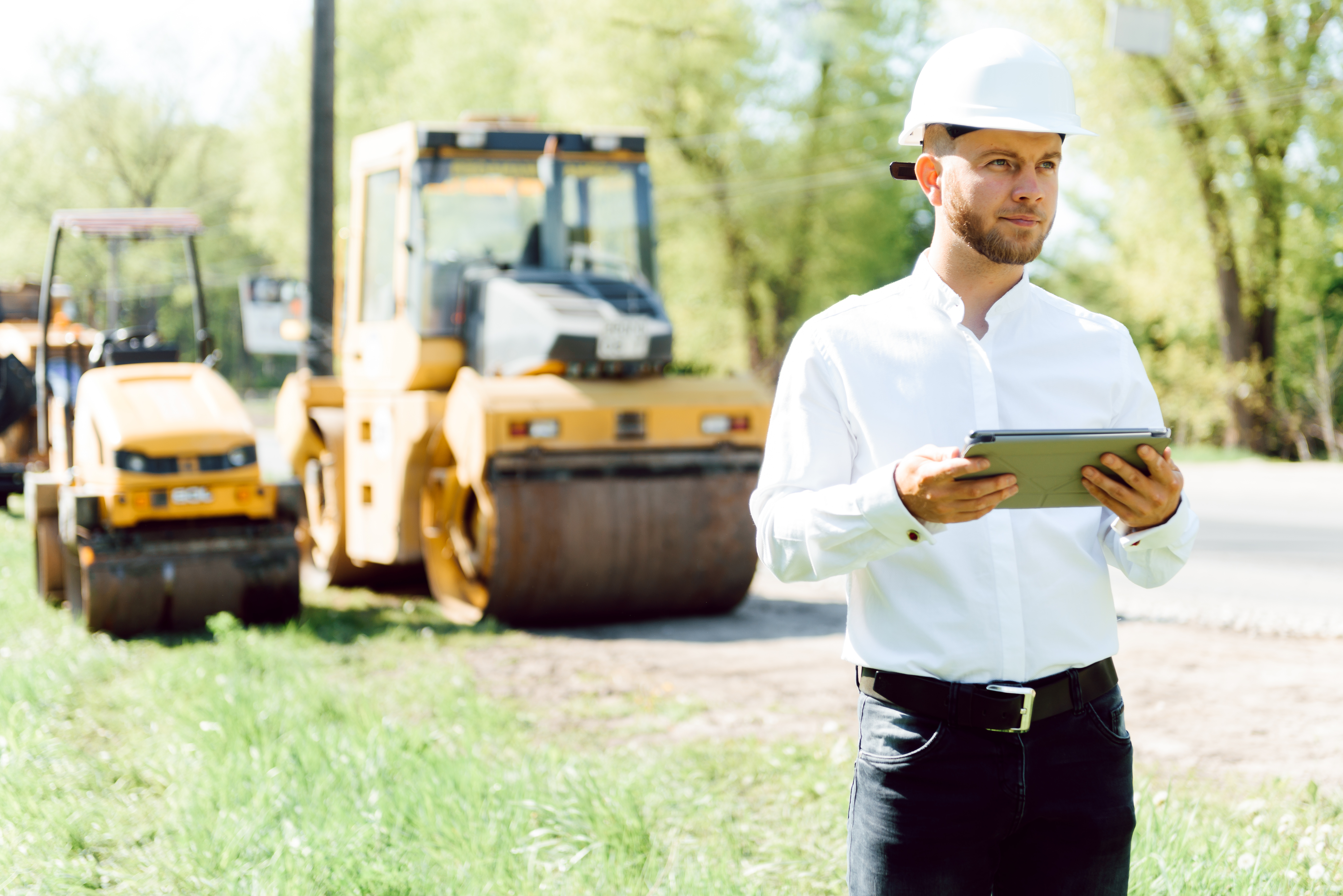 engineer near road machinery. The concept of building a new asphalt road. Road repair.