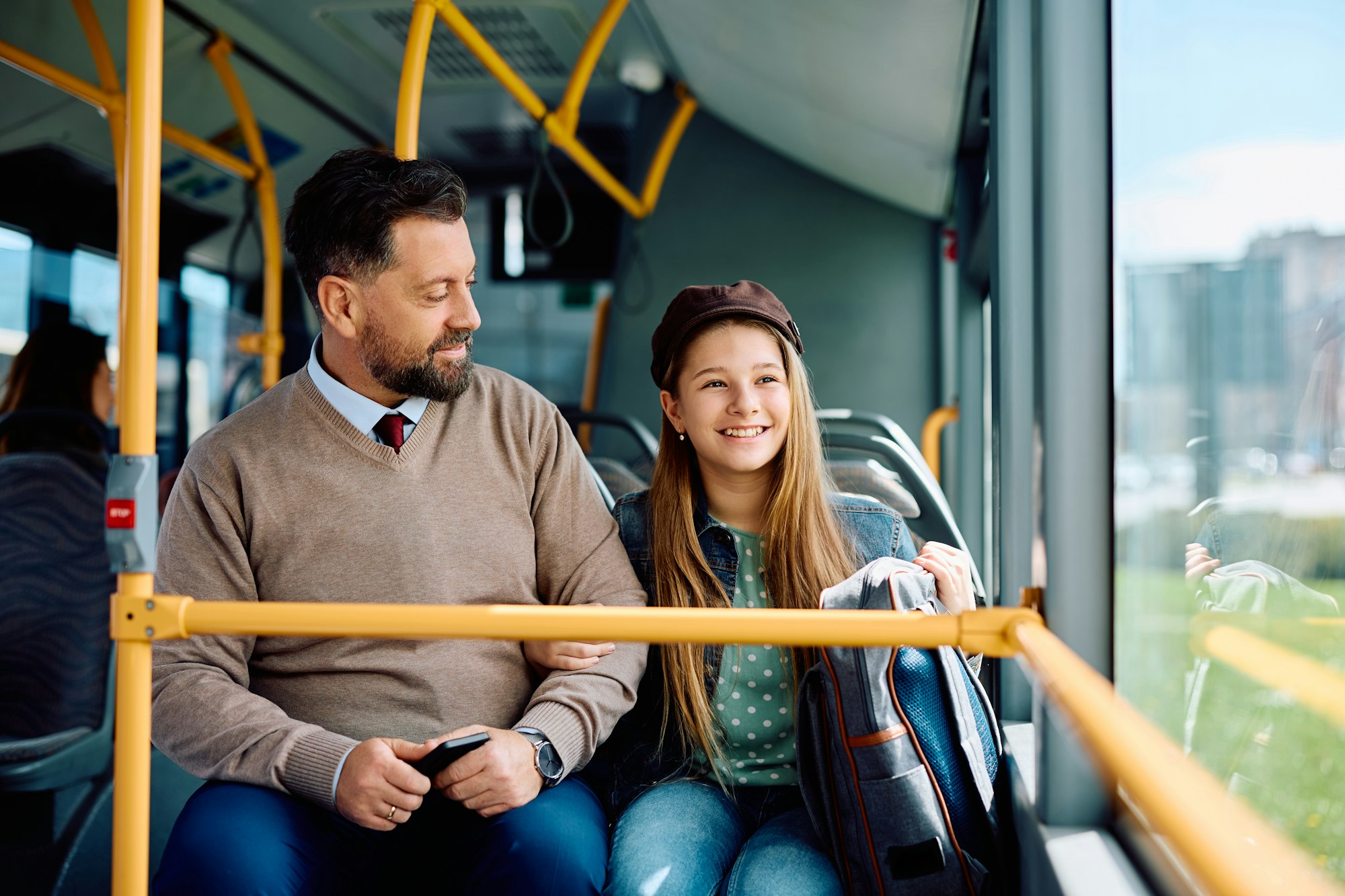Happy little girl and her father riding in public bus.