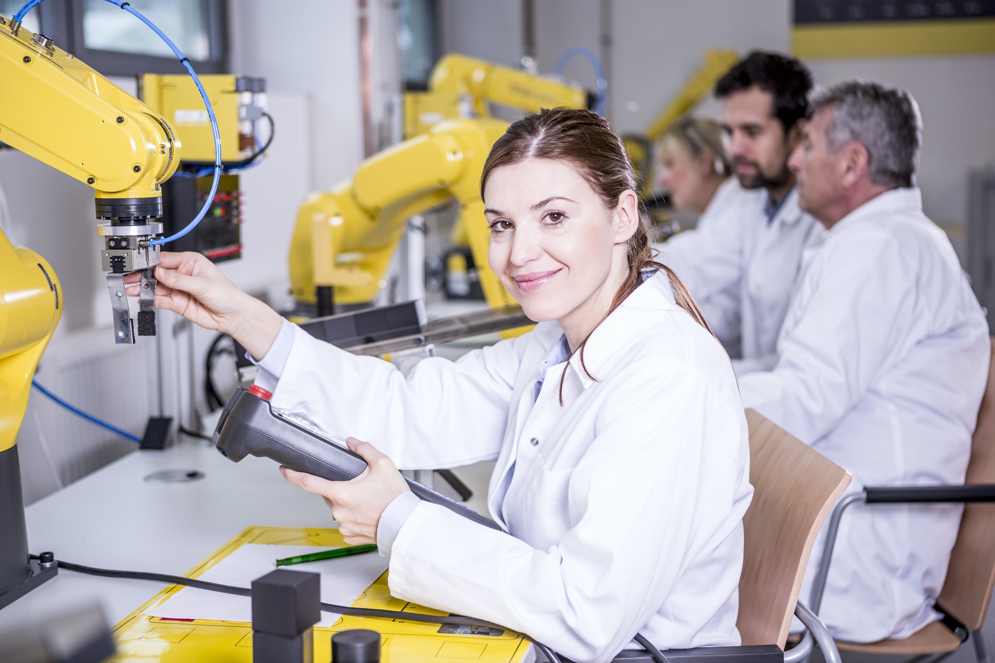 Portrait of smiling engineer examining industrial robot