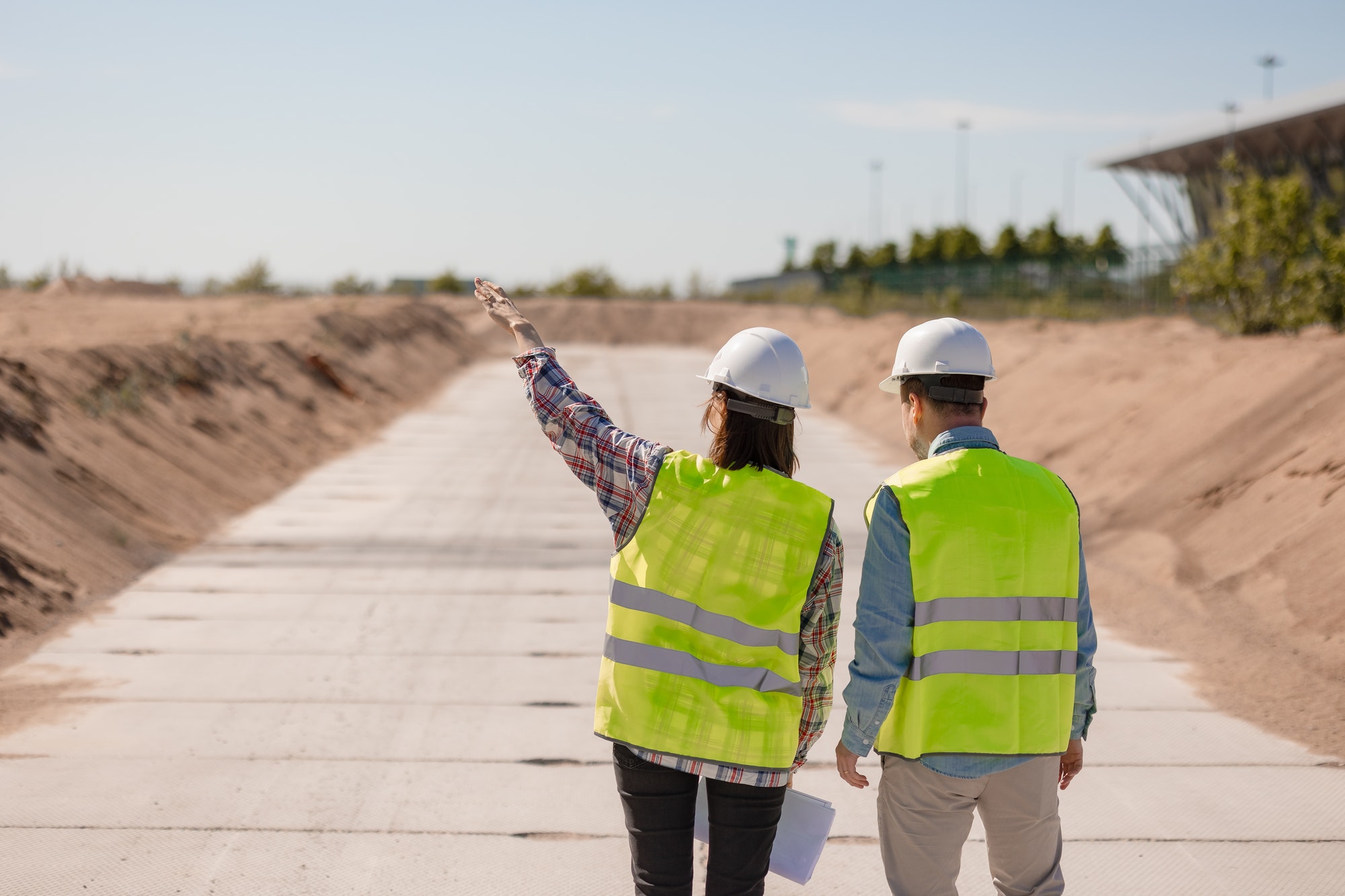 two engineers are standing on the road at the construction site of the house